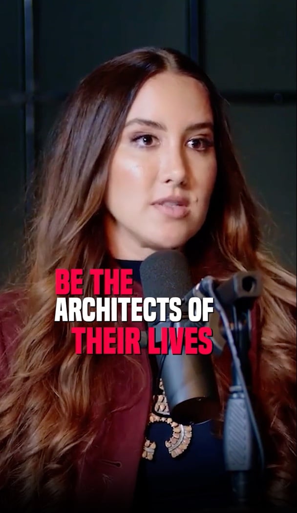 Codie sits in front of a microphone with the words "be the architects of their lives" on the screen (part of a longer quote in the video)